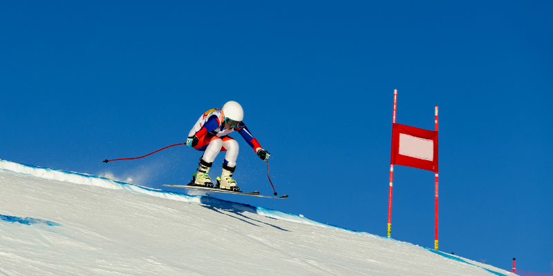 Ski racer during a turn transition, skis are not making contact with ground, legs are in line with upper body